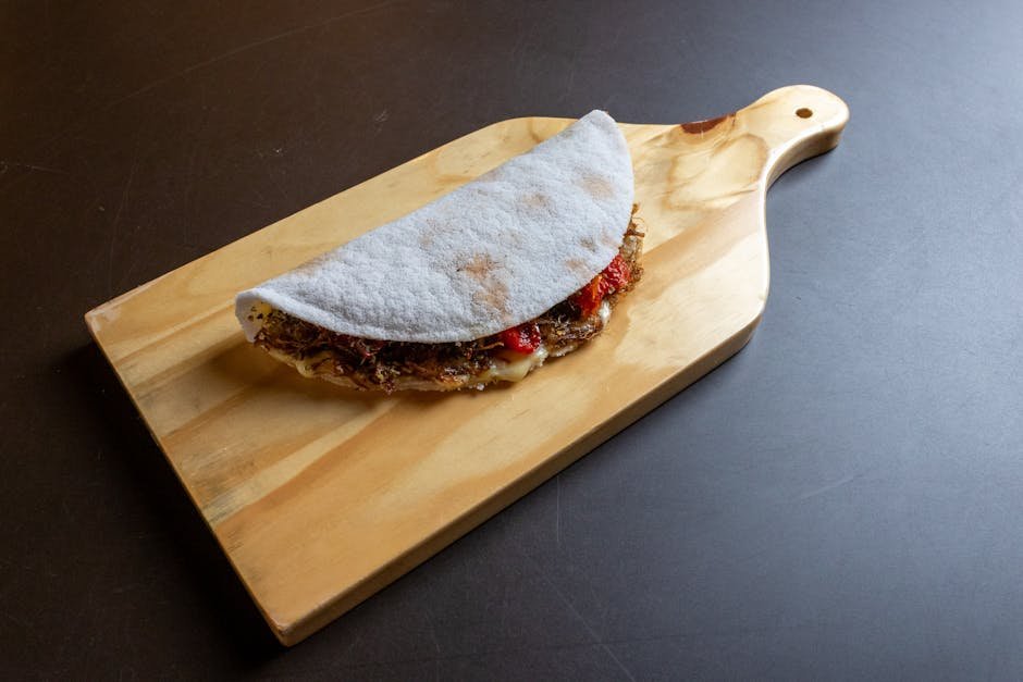 A flavorful tapioca wrap filled with ingredients displayed on a wooden board.