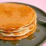 Stack of pancakes drizzled with maple syrup, perfect breakfast delight.