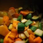 Close-up of sliced vegetables including zucchini, carrots, and peppers for a colorful and healthy dish.