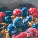 Close-up of a delicious and healthy breakfast with fresh blueberries and raspberries on cereals.