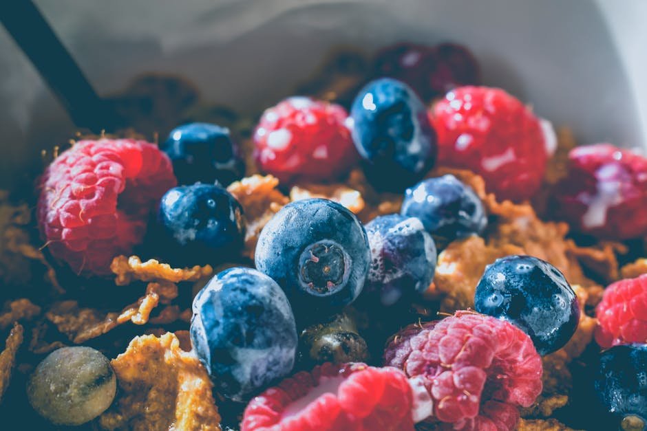 Close-up of a delicious and healthy breakfast with fresh blueberries and raspberries on cereals.