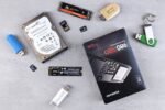 Flat lay of various computer data storage devices on a gray surface.