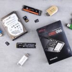 Flat lay of various computer data storage devices on a gray surface.