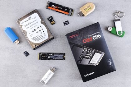Flat lay of various computer data storage devices on a gray surface.